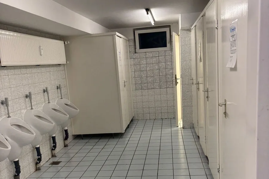 Sanitärbereich mit Urinalen und Fliesenboden in einem gewerblichen Objekt